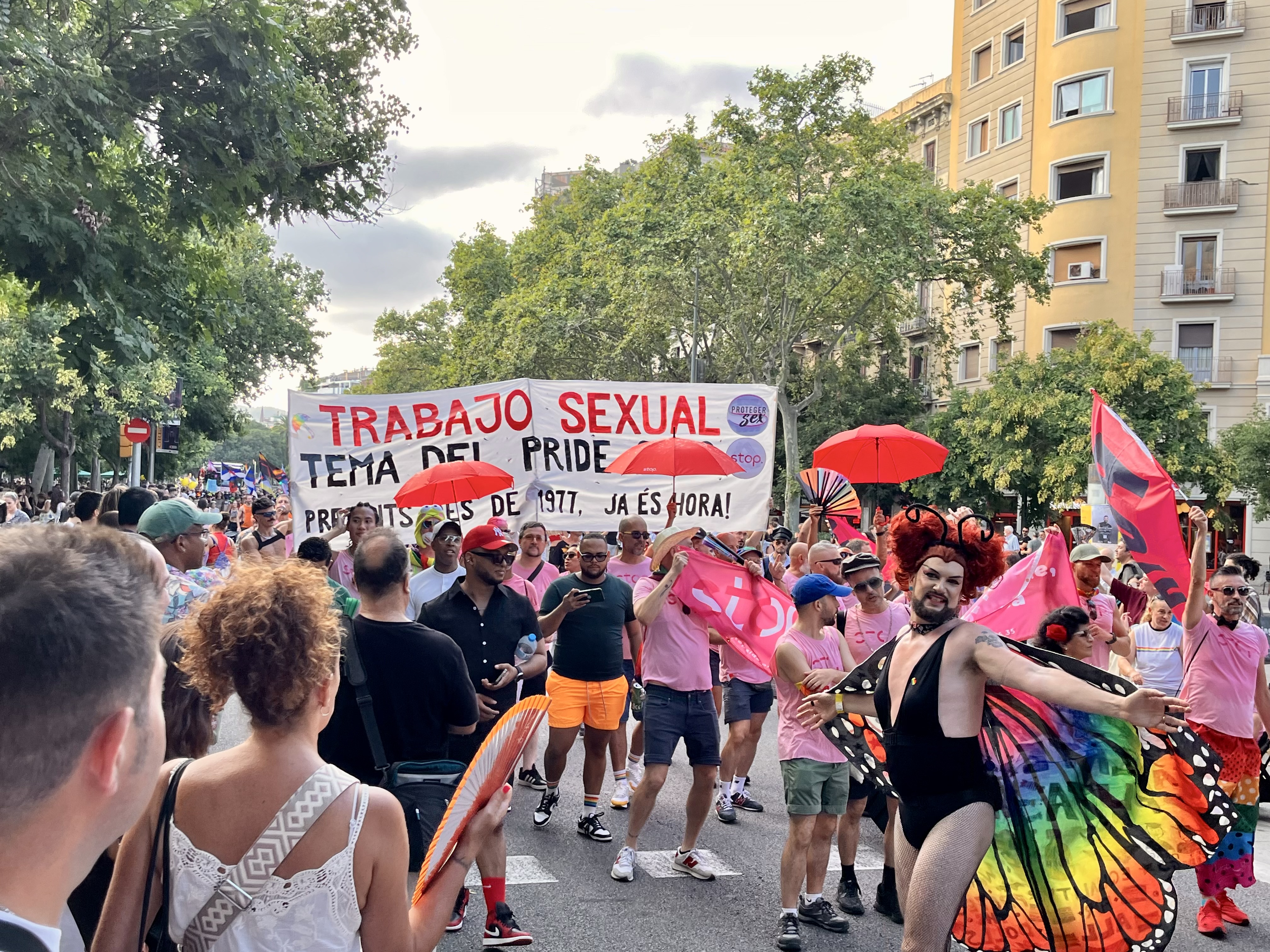 Group holding a handmade sign reading “Trabajo sexual — tema del Pride 2026” at Barcelona Pride